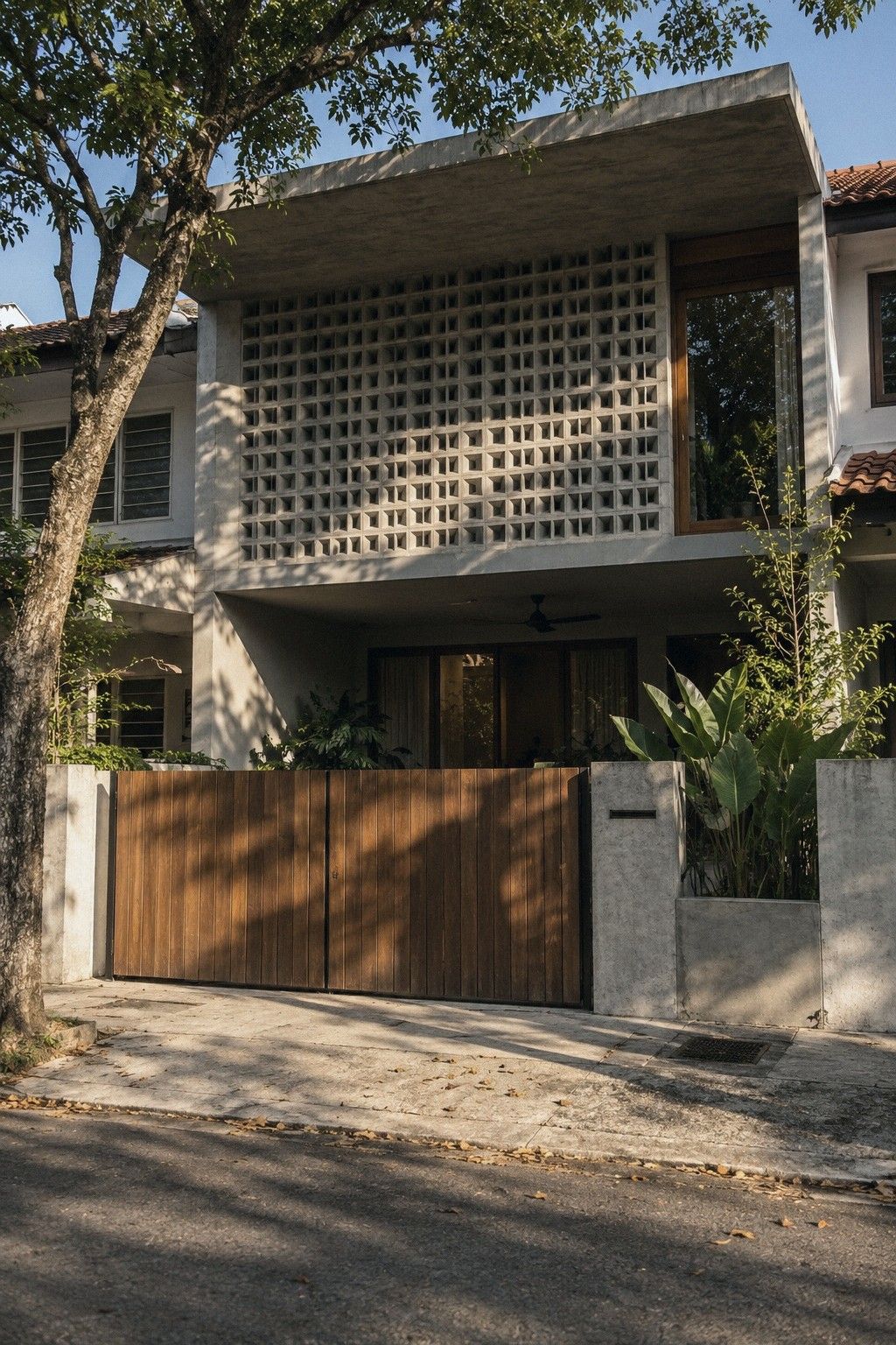 Front of the renovated terrace house: a deep porch roof and a screen of timber battens across the upstairs windows